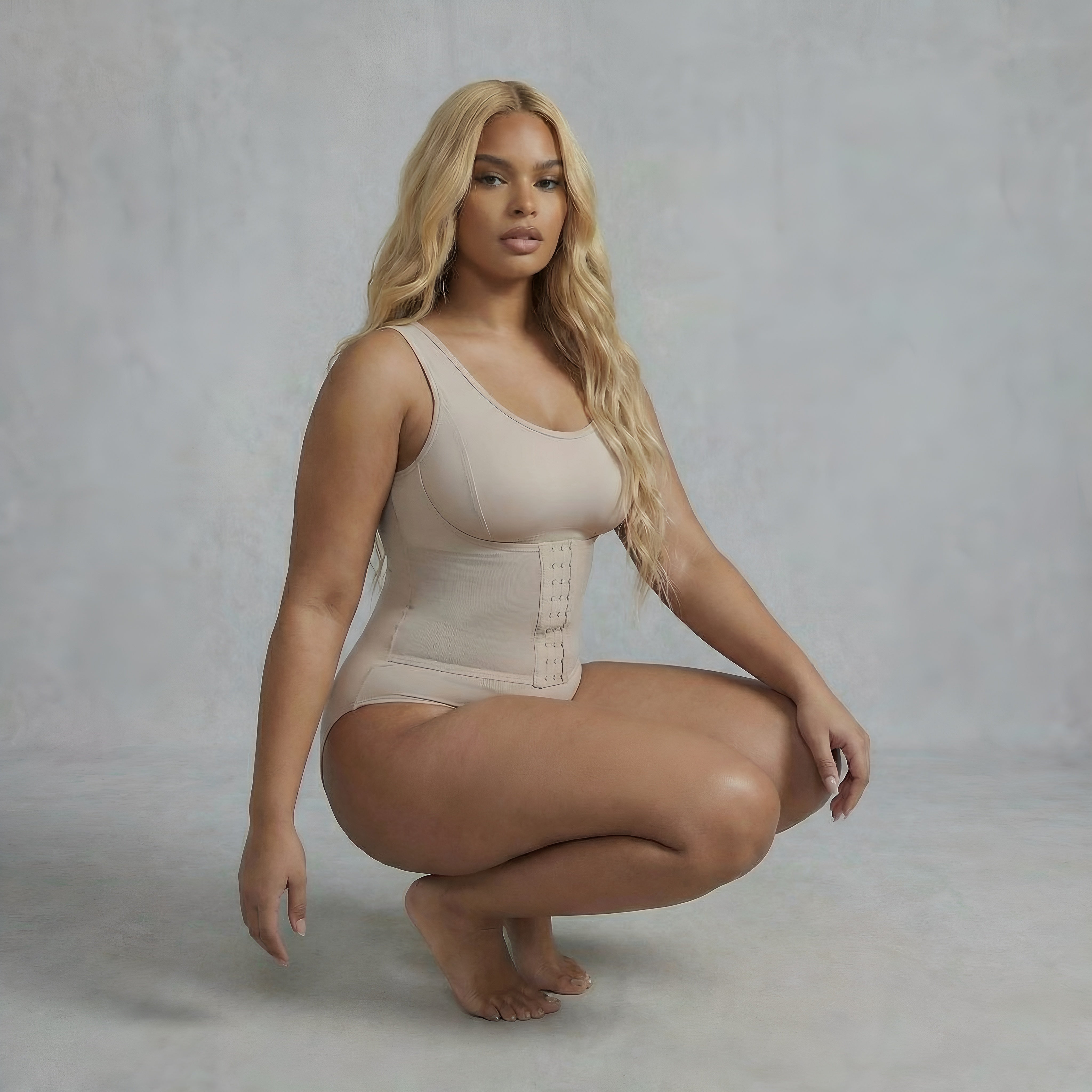 Woman wearing a beige bodysuit against a plain background. Curvy shapewear woman bodysuit lyvia.