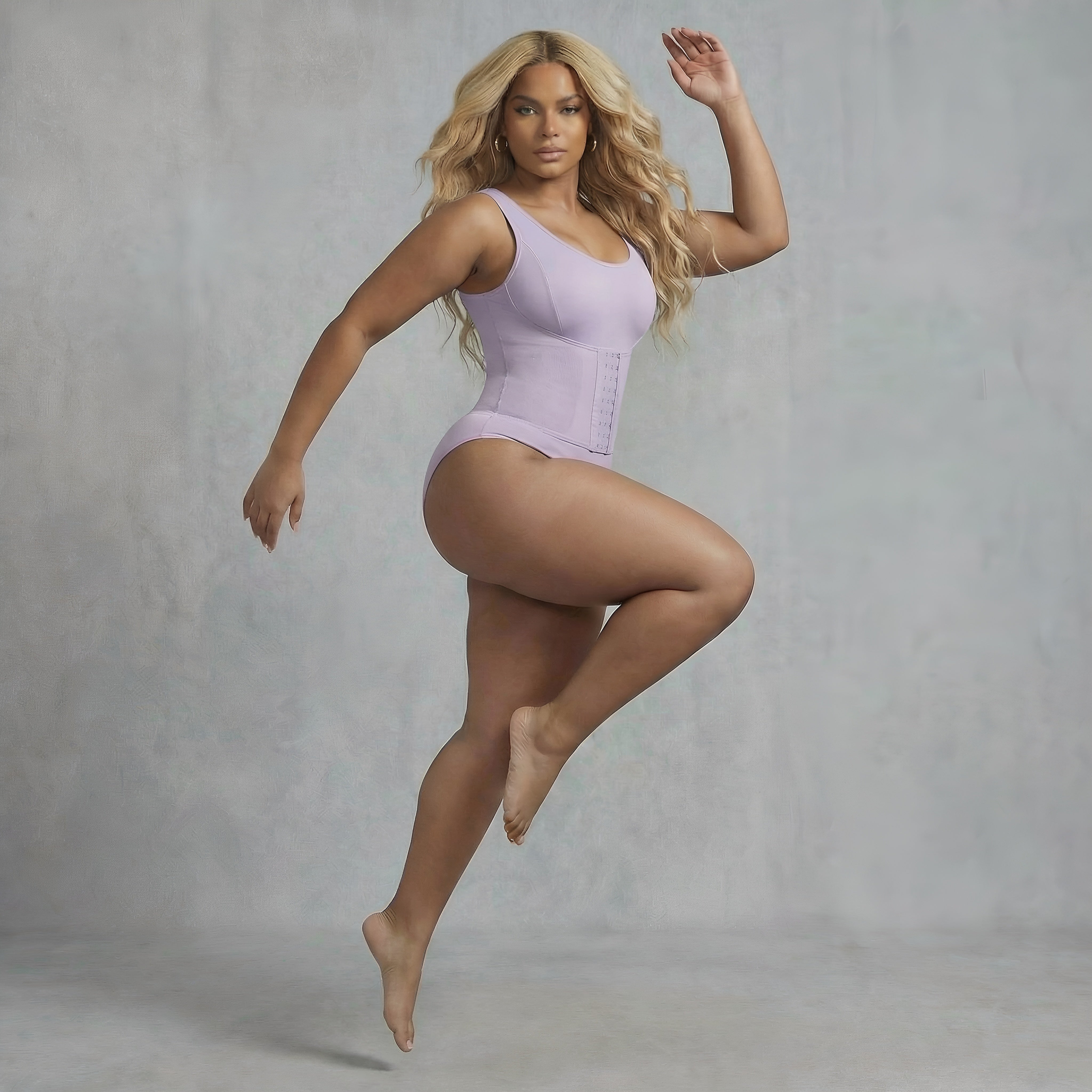 Woman wearing a light purple bodysuit against a gray background. Purple bodysuit shapewear womans lyvia curvy.