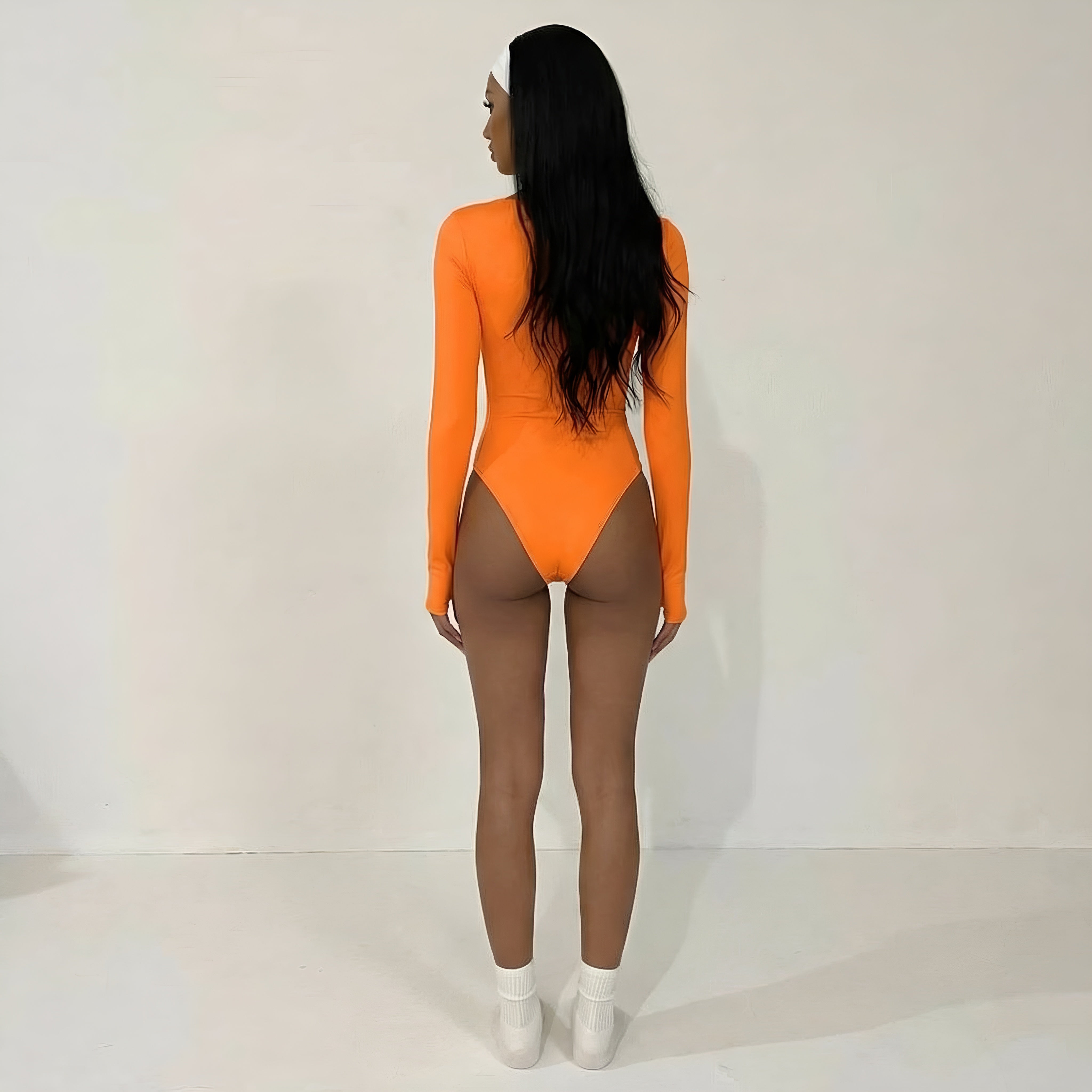Person wearing an orange bodysuit on a plain background. Orange womans shapewear bodysuit lyvia.